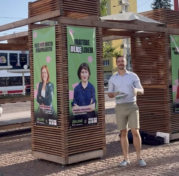 Dobrovolník kampaně rozdává letáky